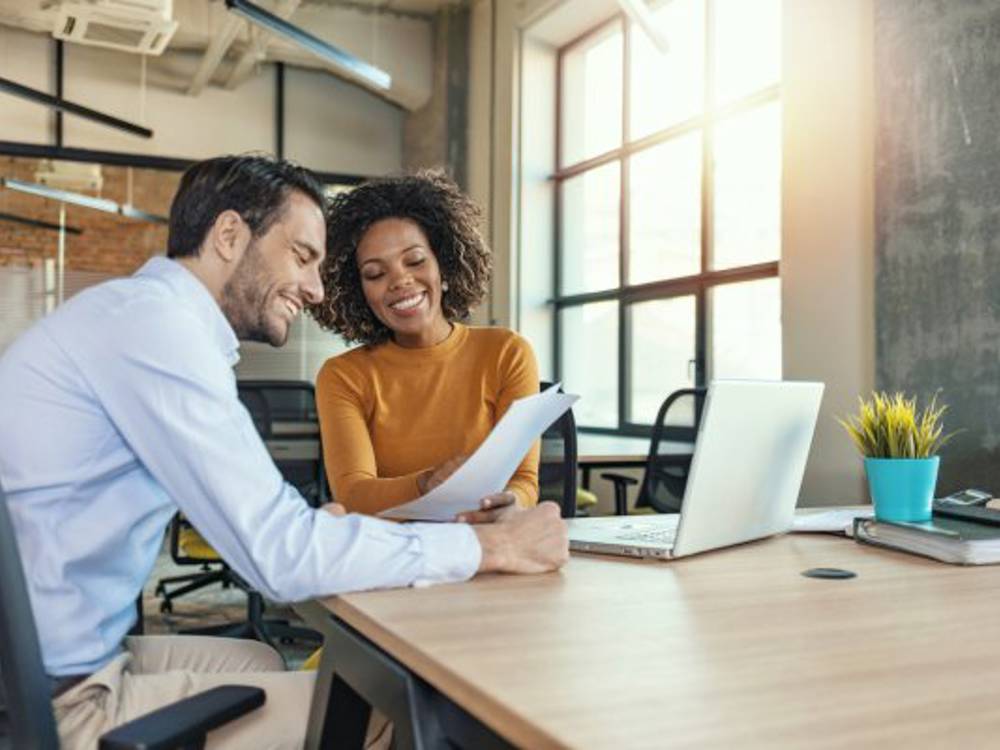 Two Business People Looking At Paper
